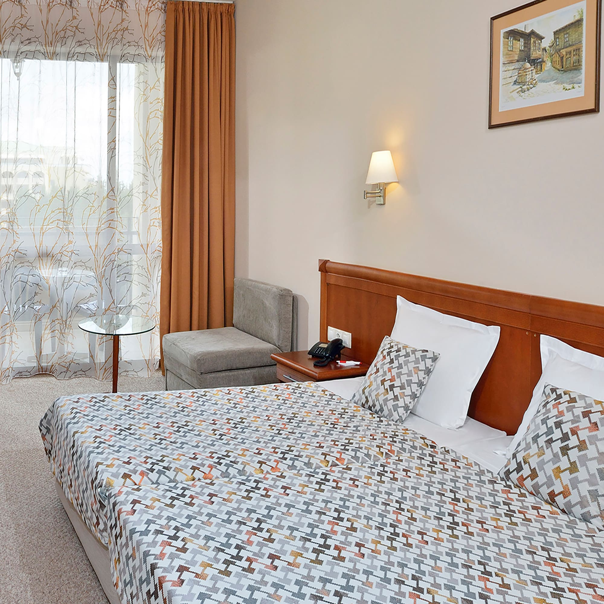 a bed with a patterned bedding and a table in a room