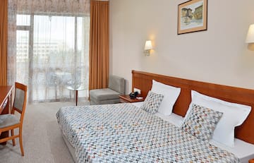 a bed with a patterned bedding and a table in a room