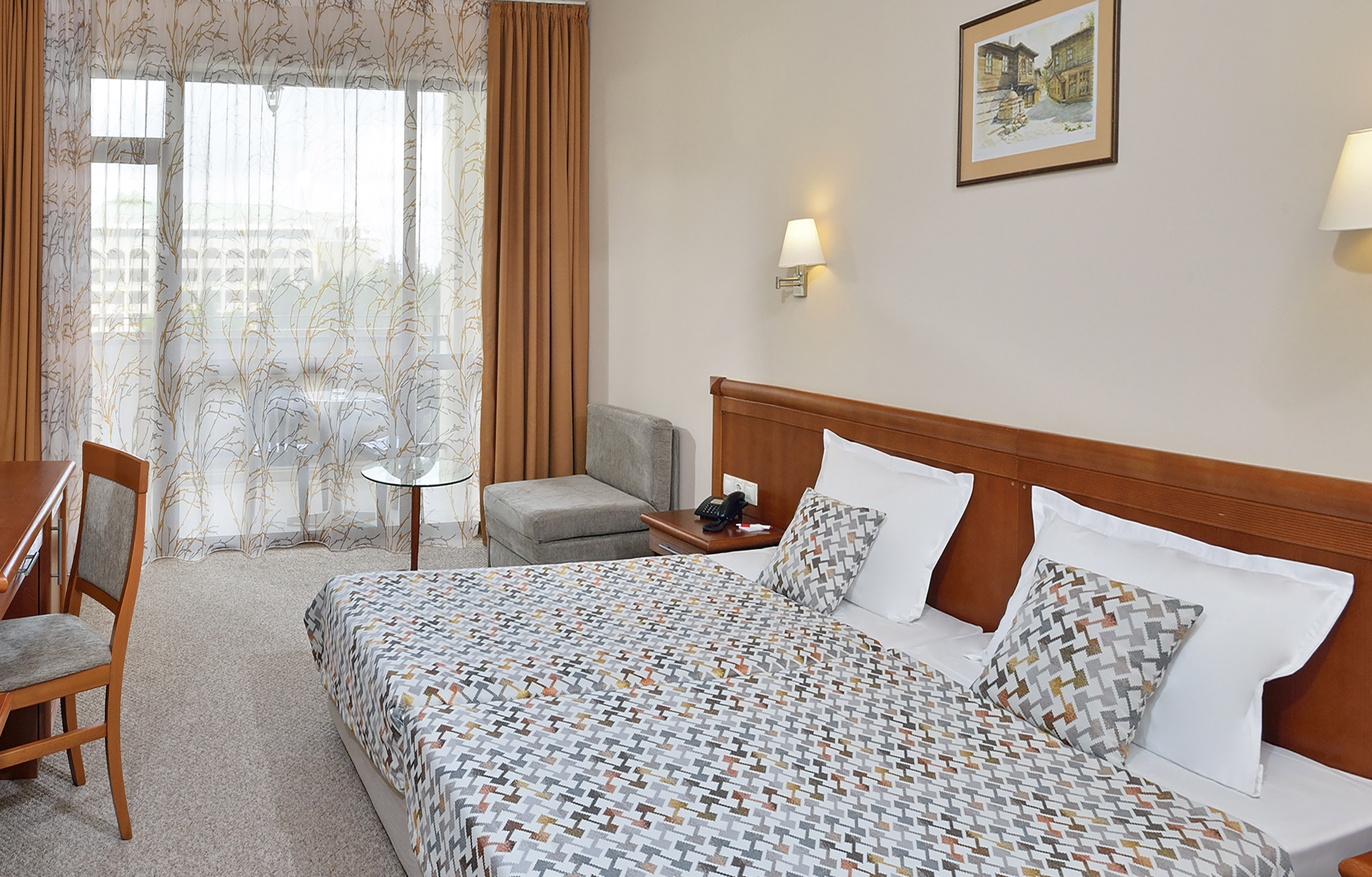 a bed with a patterned bedding and a table in a room