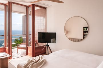 a room with a television and a view of the ocean