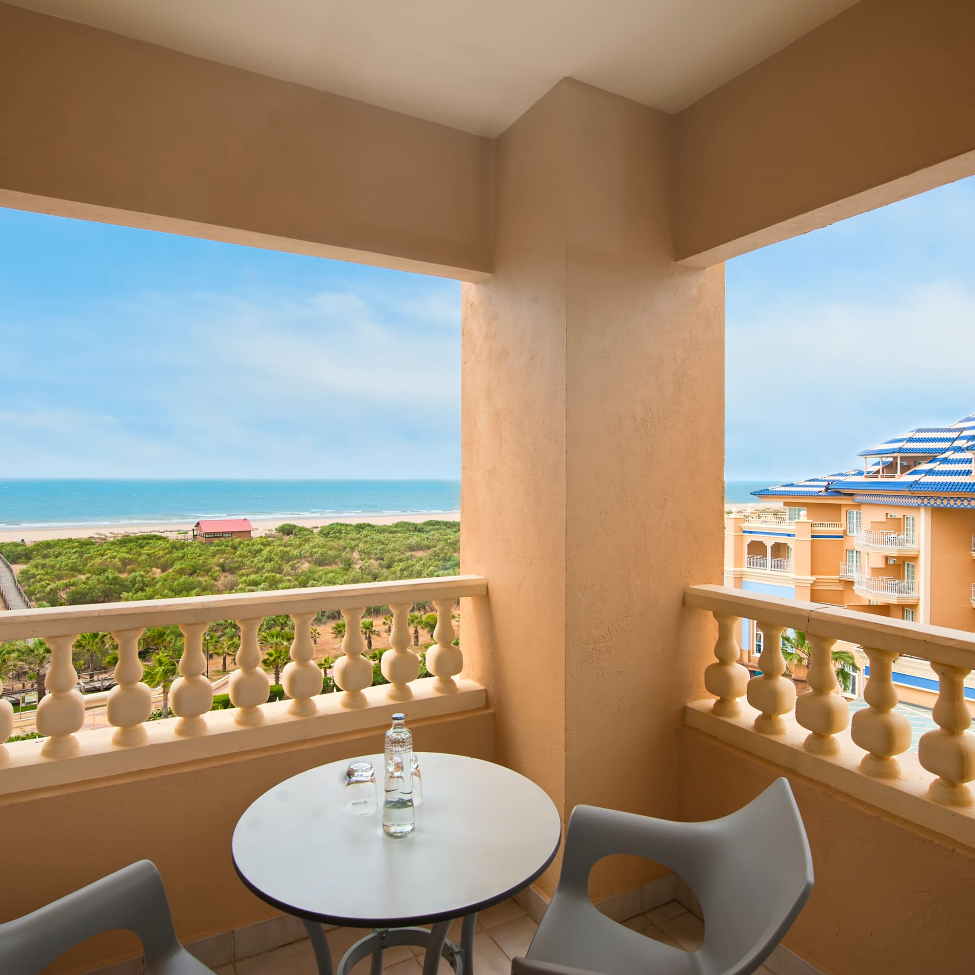 a balcony with a table and chairs overlooking a beach