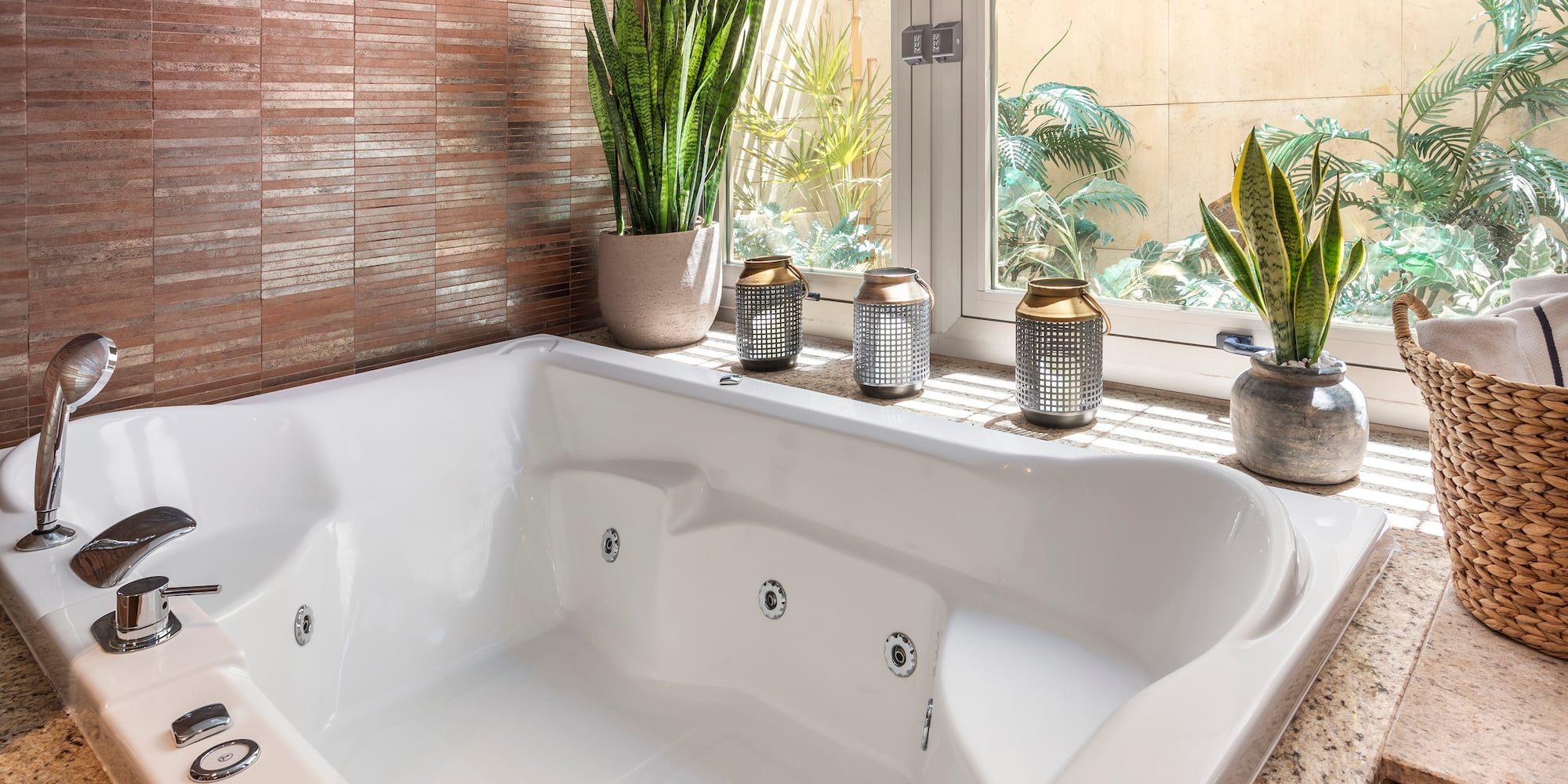 a white bathtub with a window and plants in the background