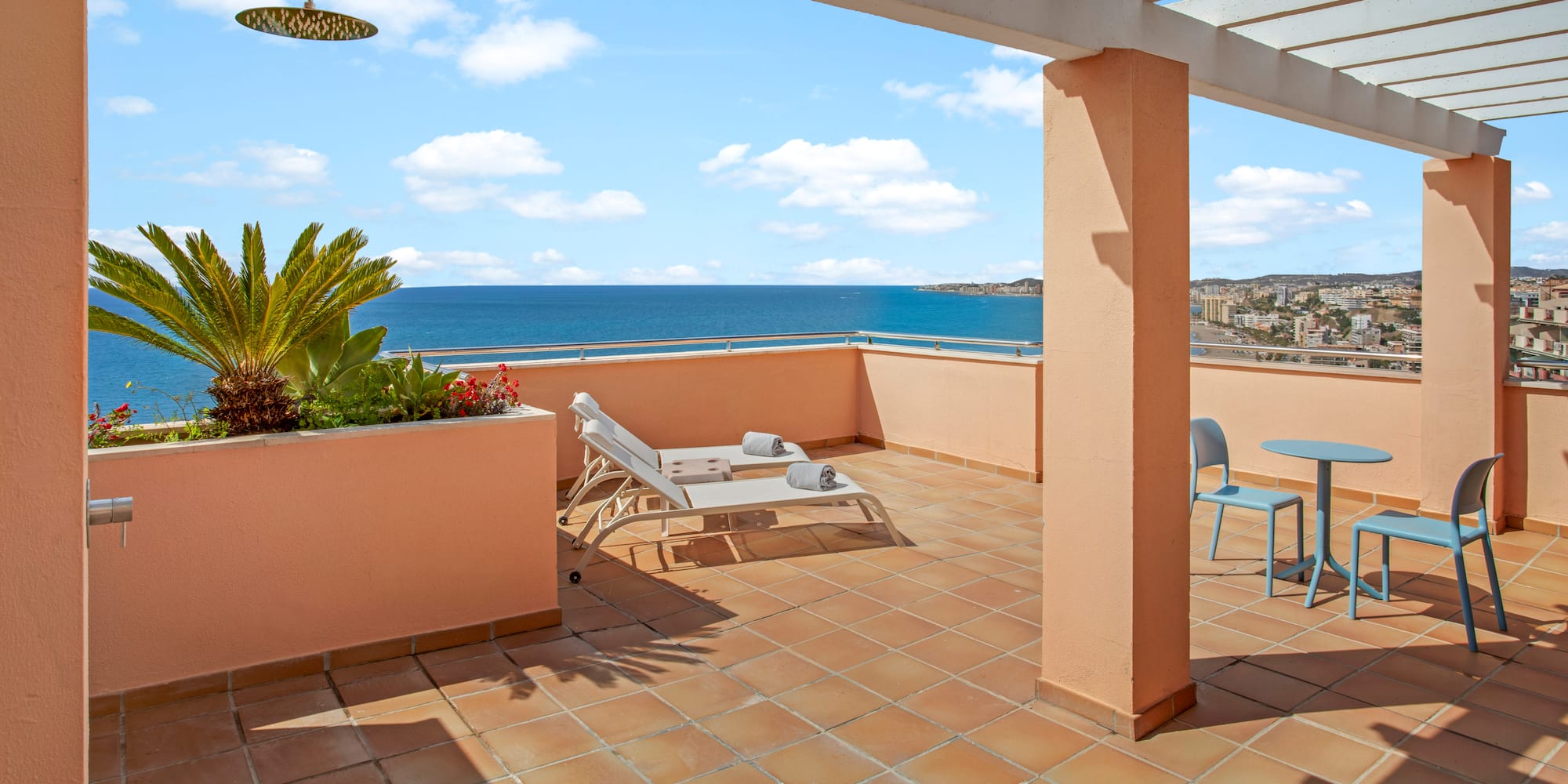 Spacious terrace with ocean view, pergola, sun loungers, and outdoor shower.