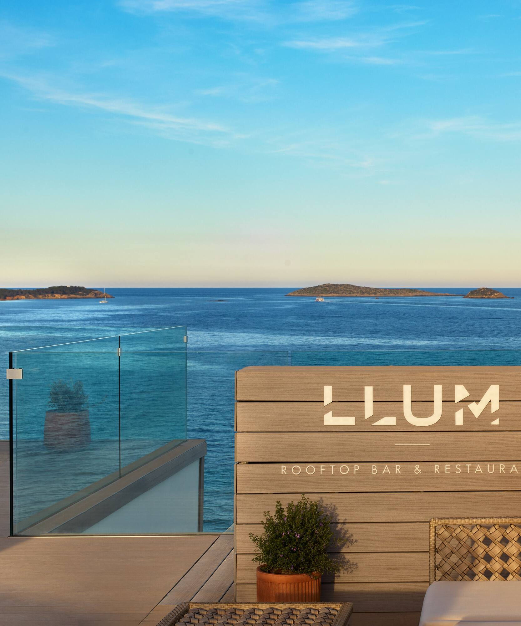 a deck with chairs and a railing overlooking the ocean