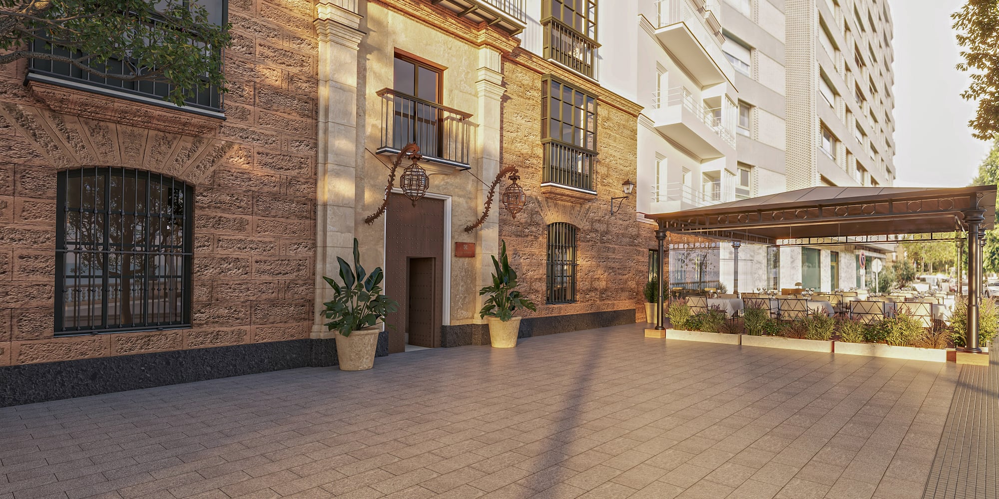 Old stone facade, modern building, paved patio, outdoor cafe terrace with tables.