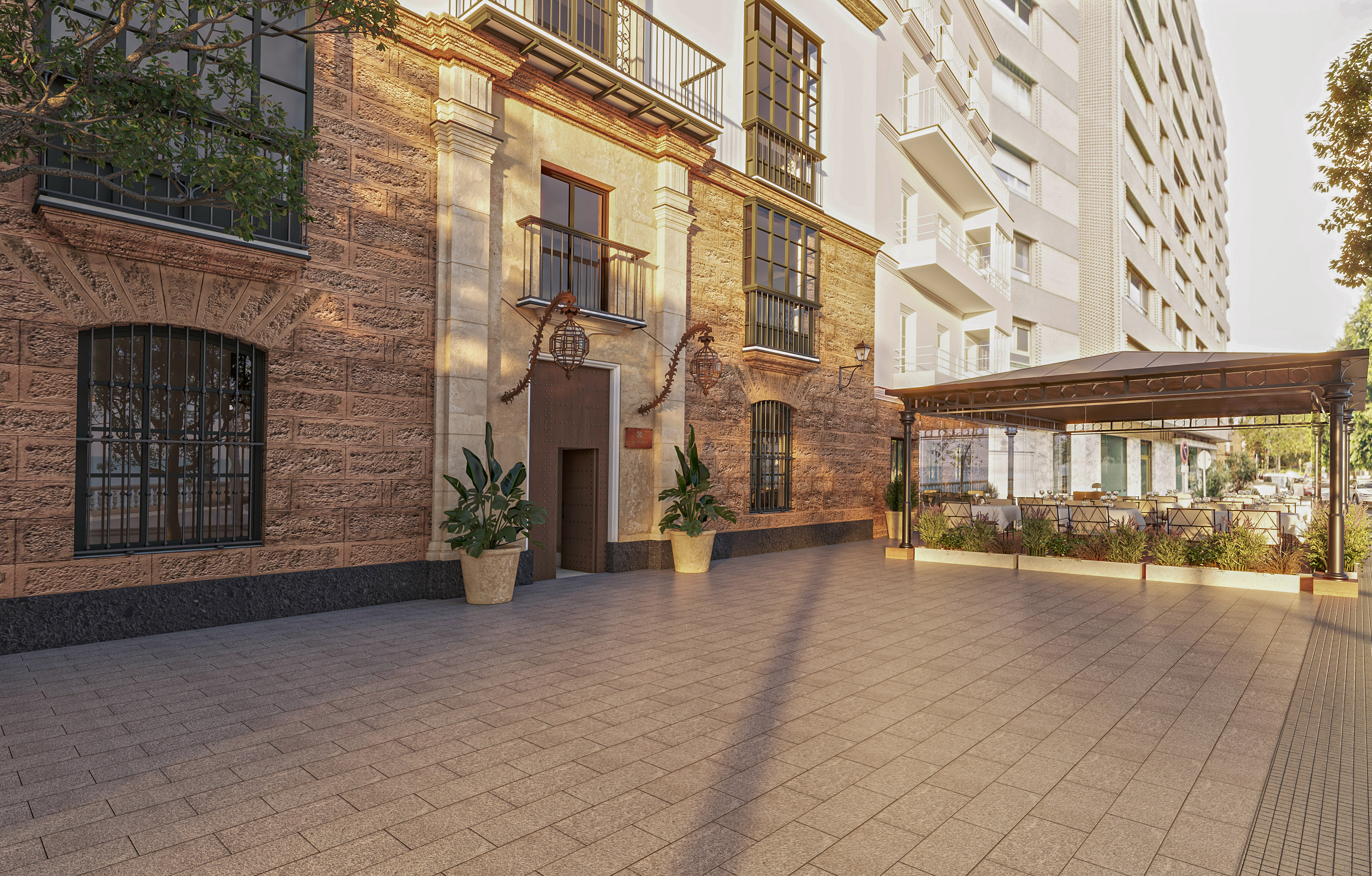 Old stone facade, modern building, paved patio, outdoor cafe terrace with tables.