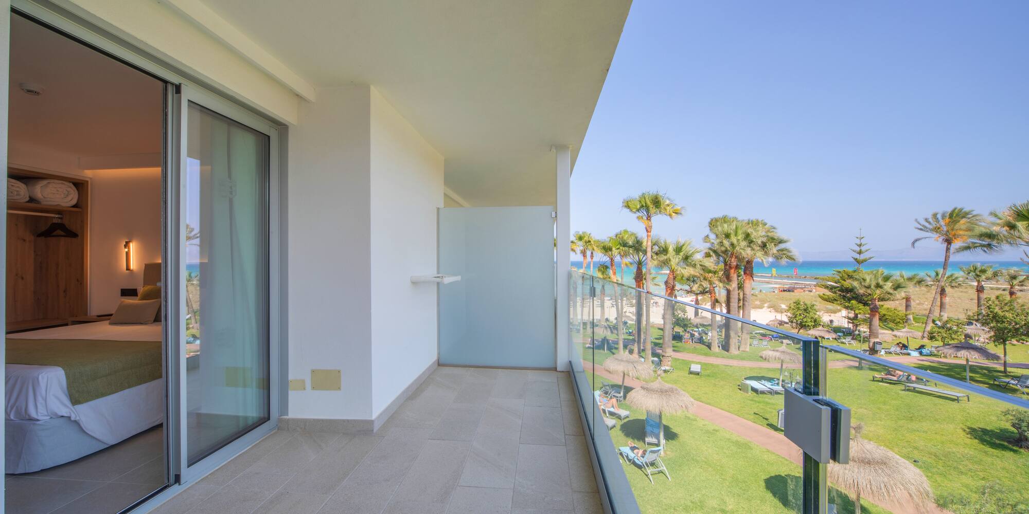 a balcony with a view of the beach and palm trees