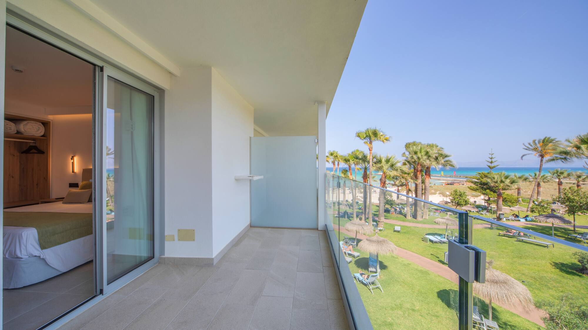 a balcony with a view of the beach and palm trees