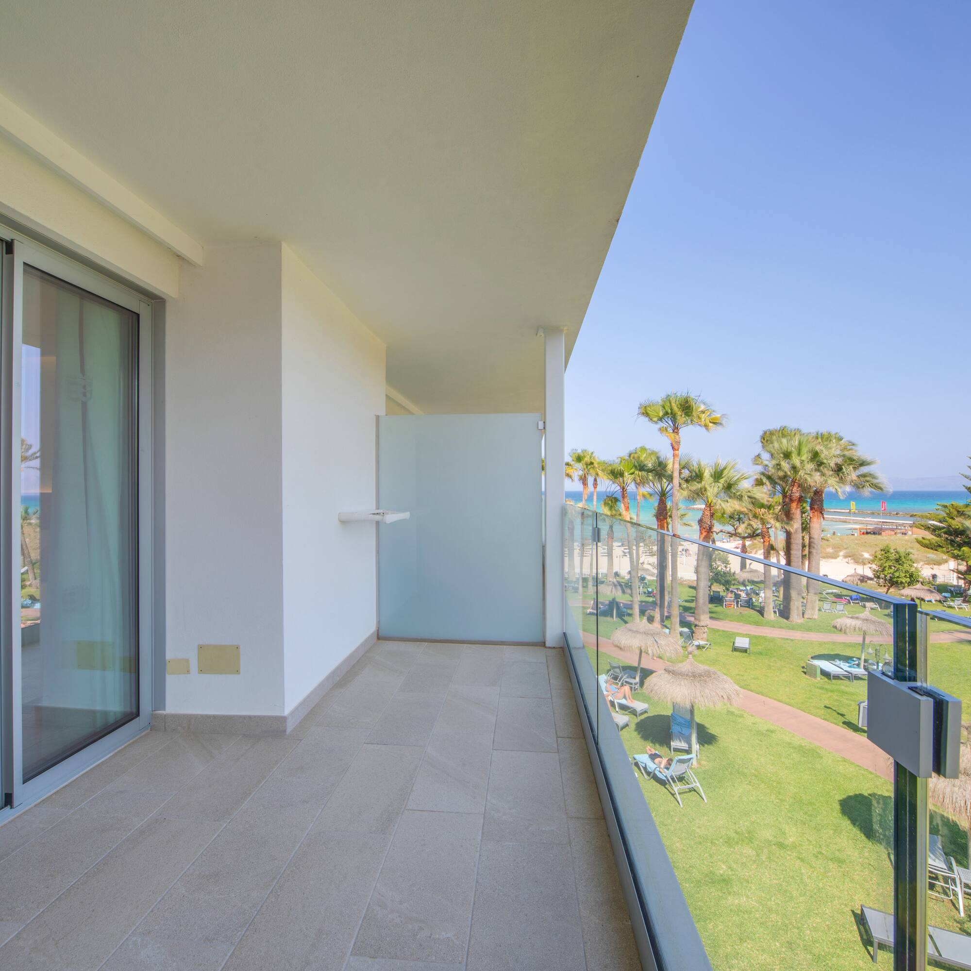 a balcony with a view of the beach and palm trees
