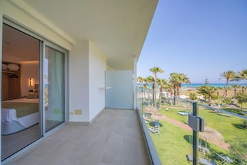 a balcony with a view of the beach and palm trees