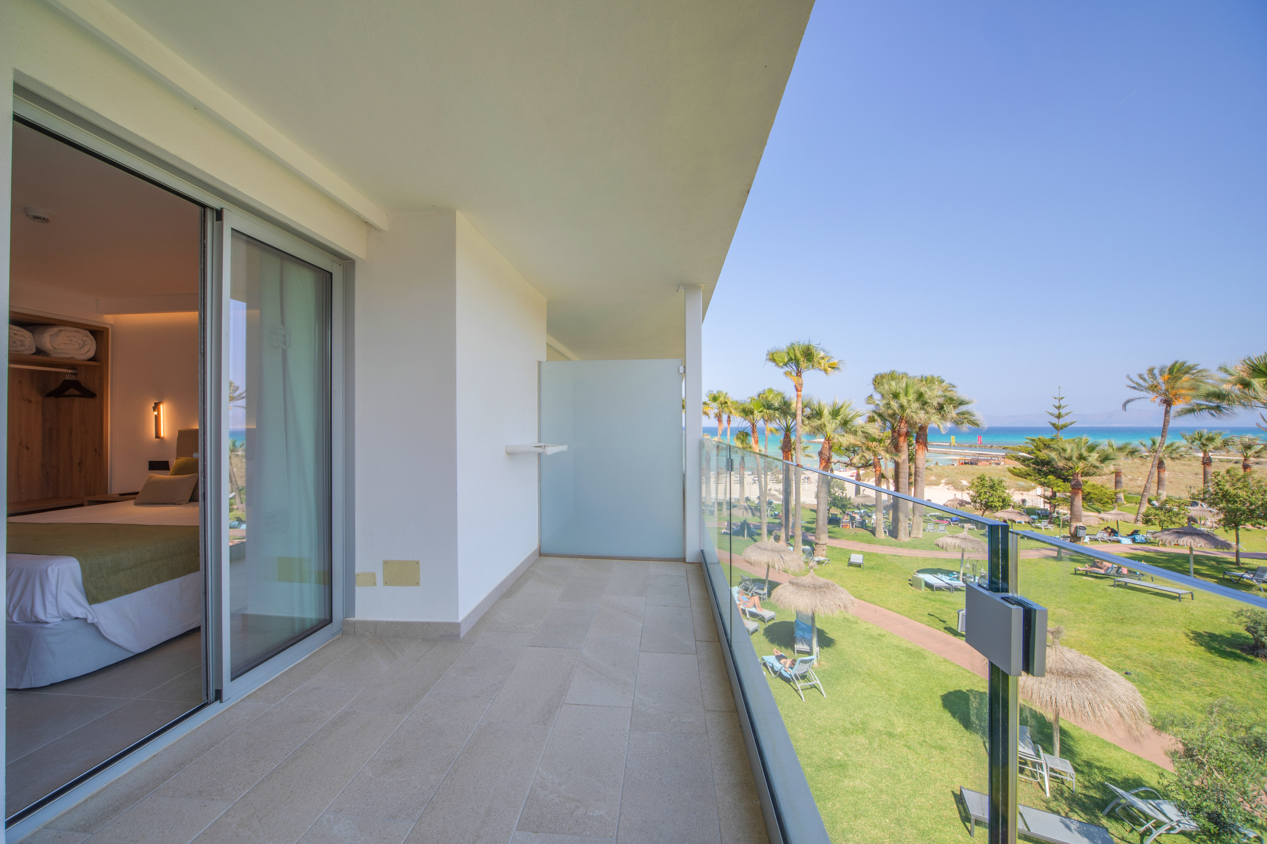a balcony with a view of the beach and palm trees