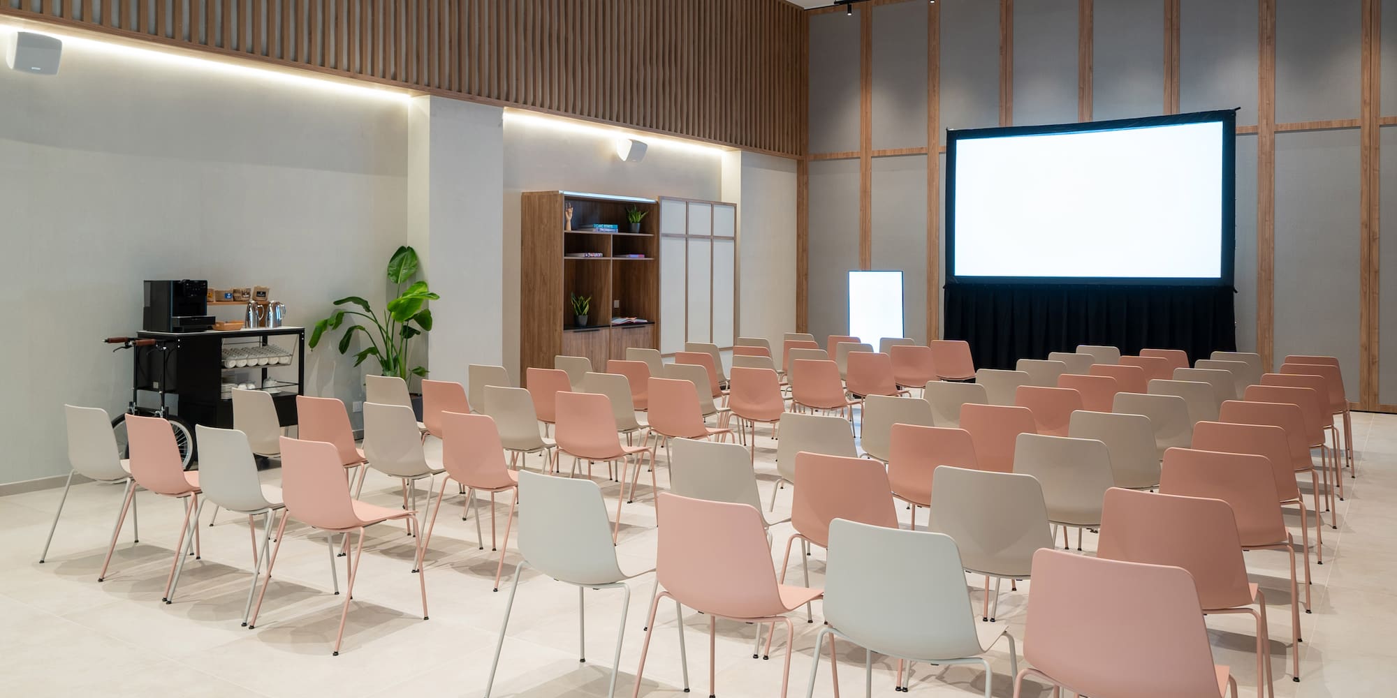 a room with rows of chairs and a projector screen
