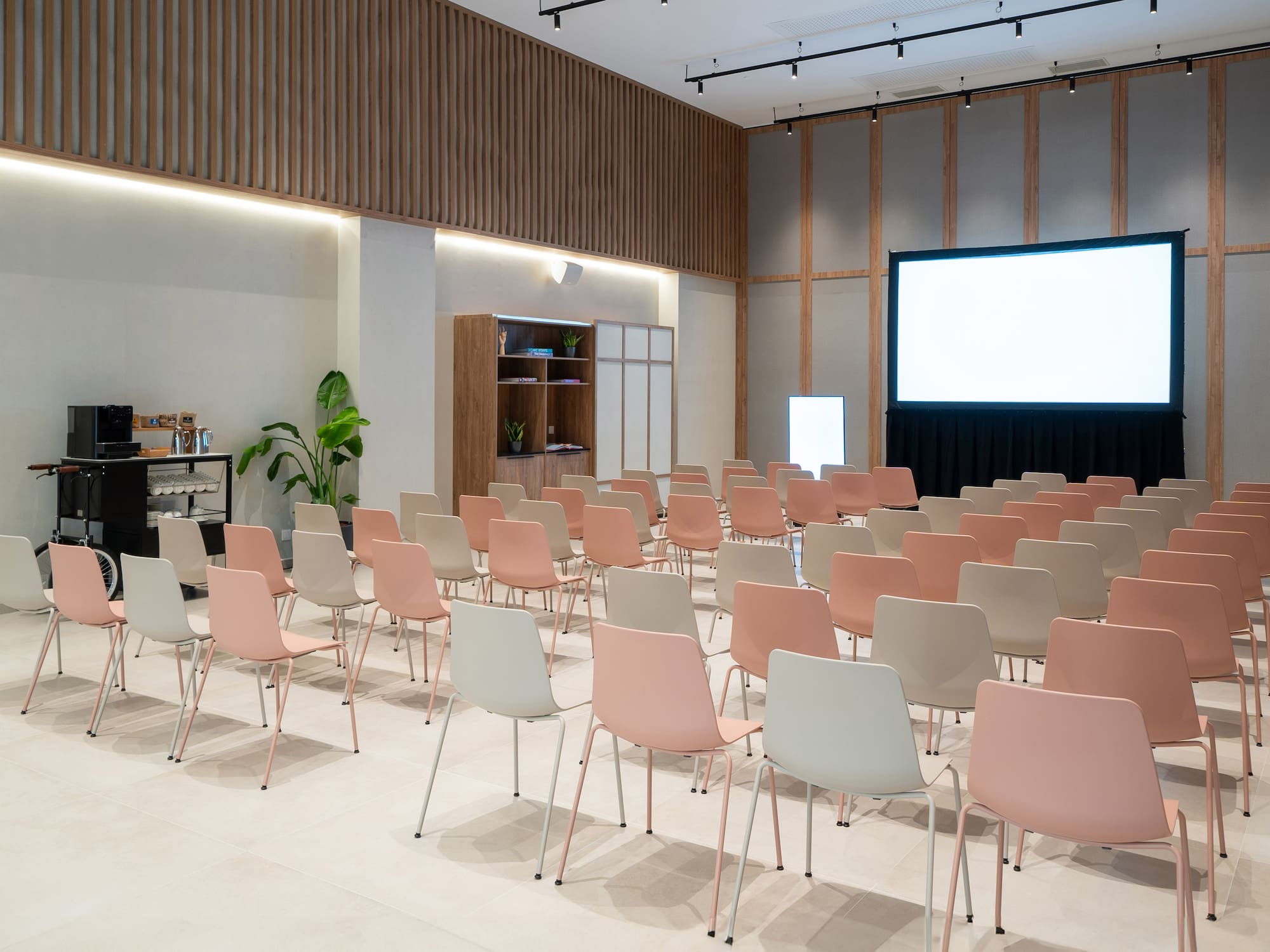 a room with rows of chairs and a projector screen
