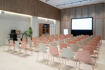 a room with rows of chairs and a projector screen