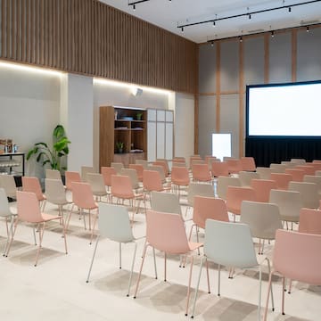 a room with rows of chairs and a projector screen