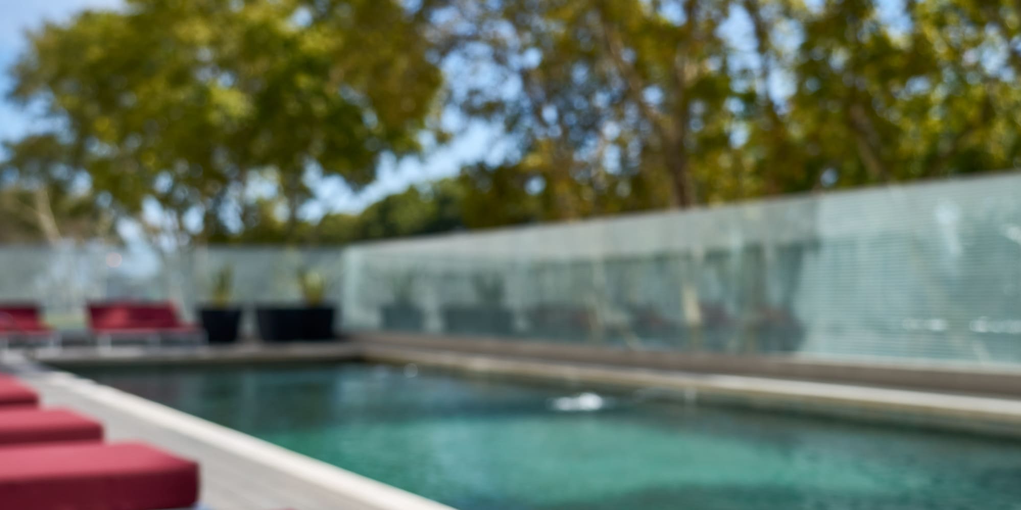 a hat and sunglasses on a towel next to a pool
