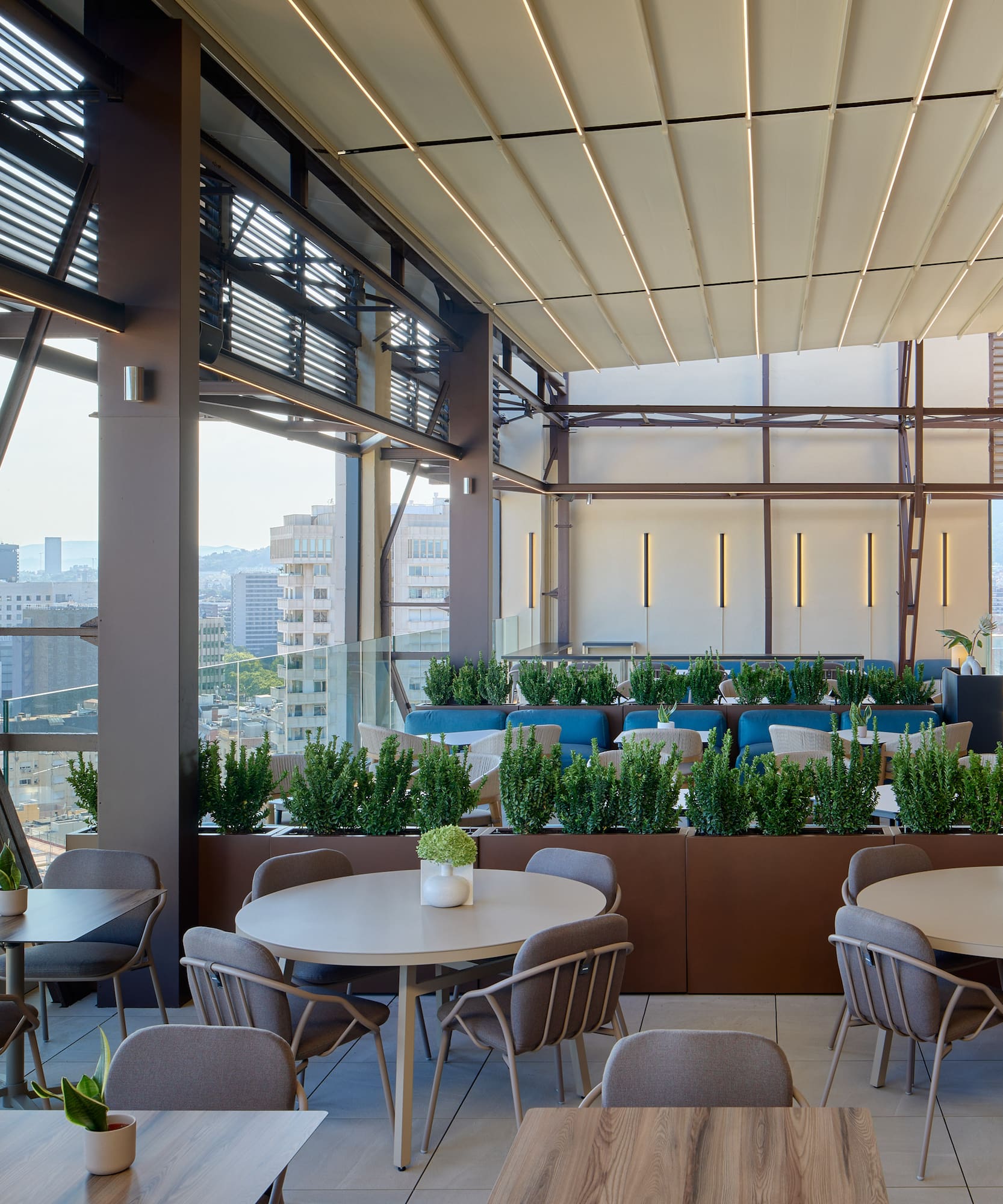 Rooftop restaurant terrace with modern outdoor seating and city view.