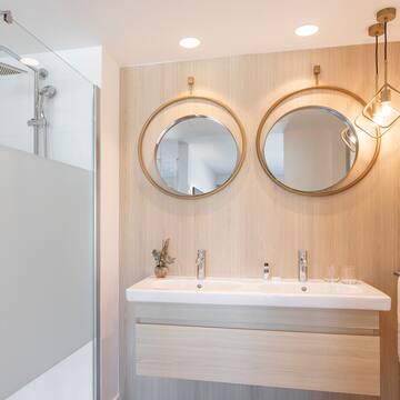 a bathroom with a shower and two mirrors
