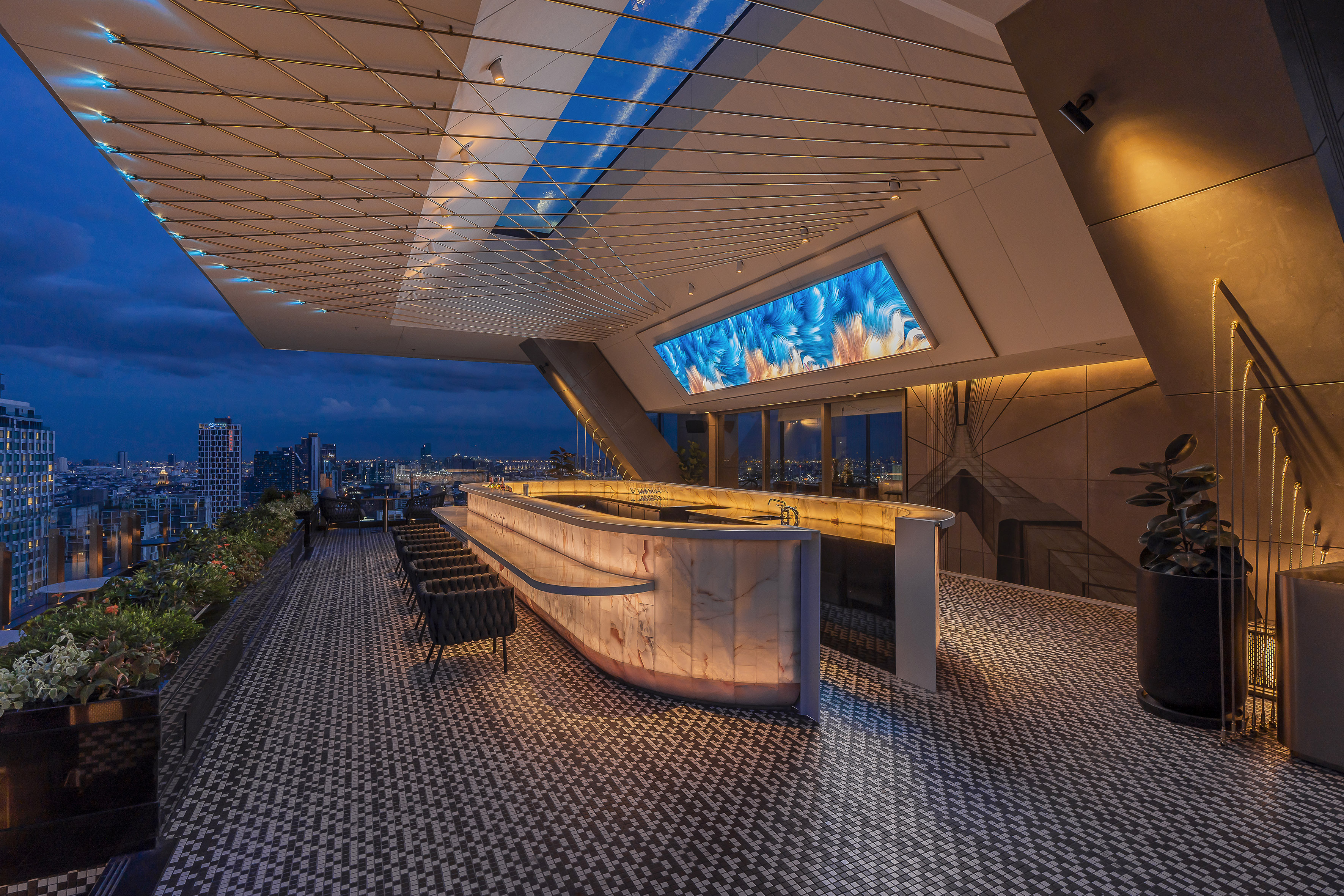 Luxury rooftop bar with glowing onyx counter, city skyline, and modern design.