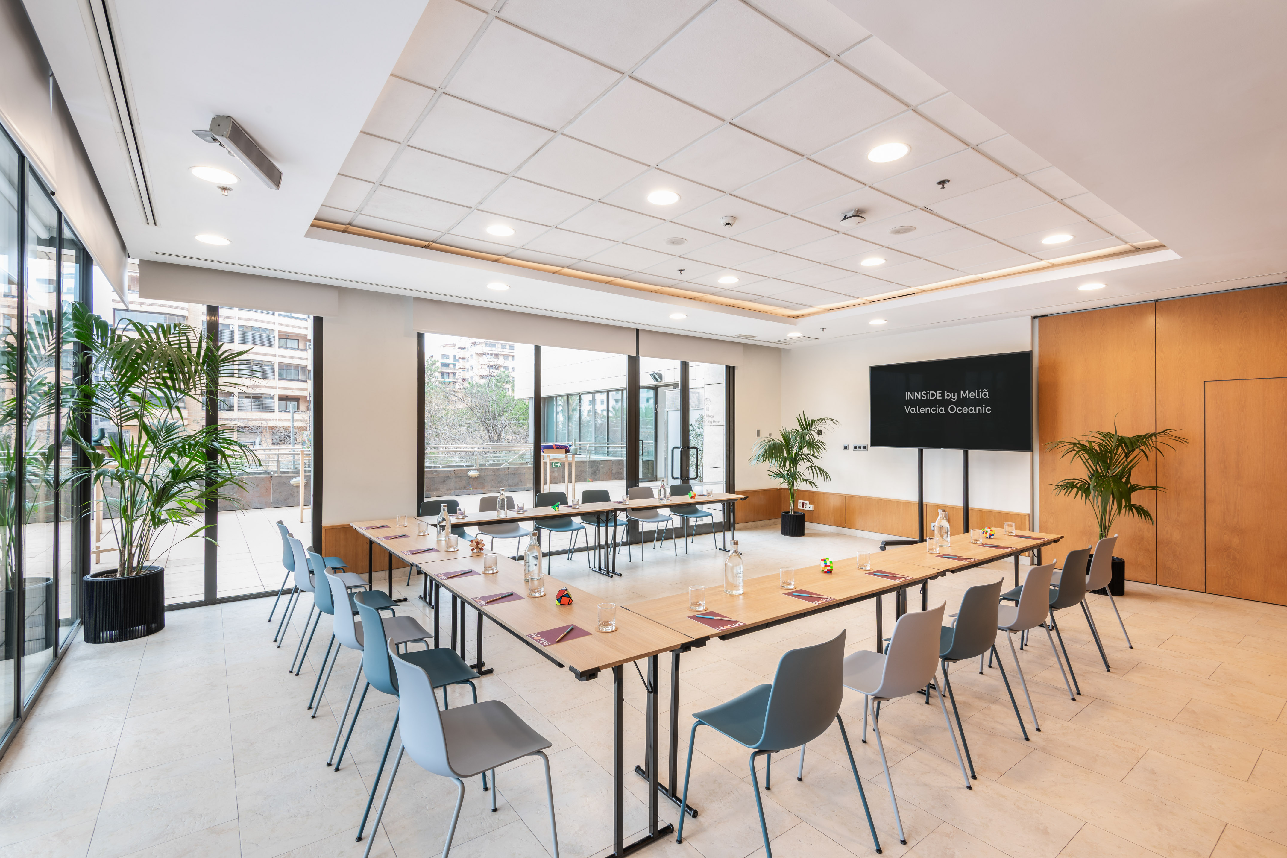 INNSiDE by Meliá conference room with U-table setup, natural light, and plants.