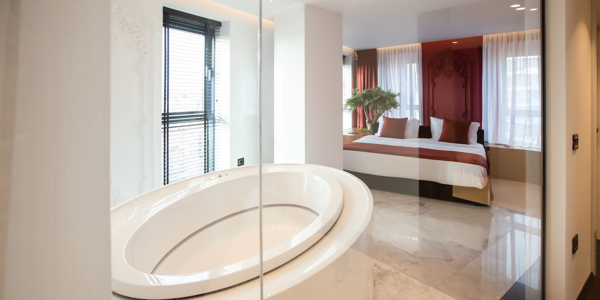 a bathroom with a large oval tub and a bed