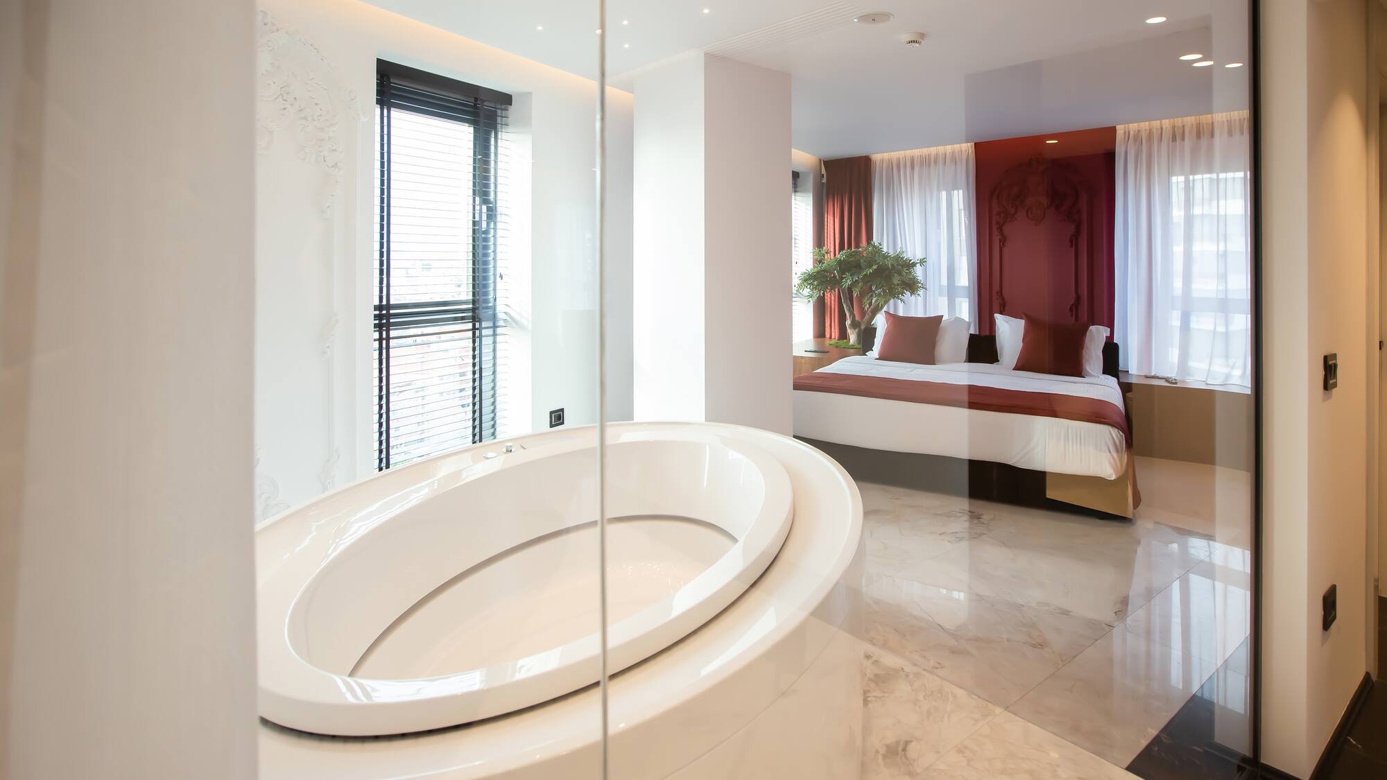 a bathroom with a large oval tub and a bed