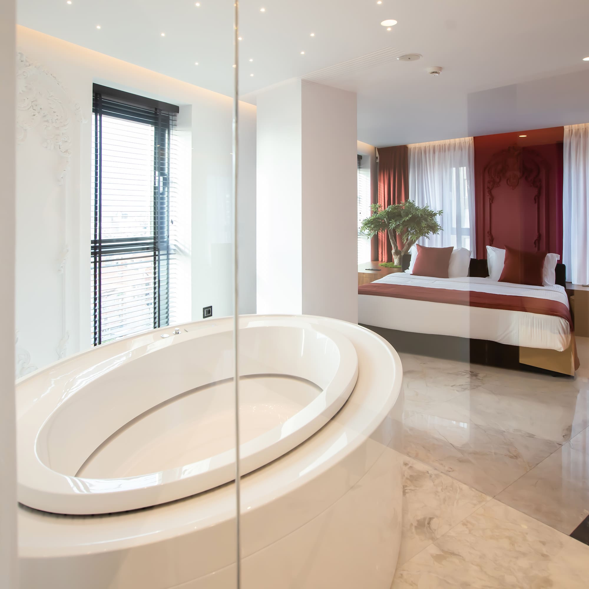 a bathroom with a large oval tub and a bed