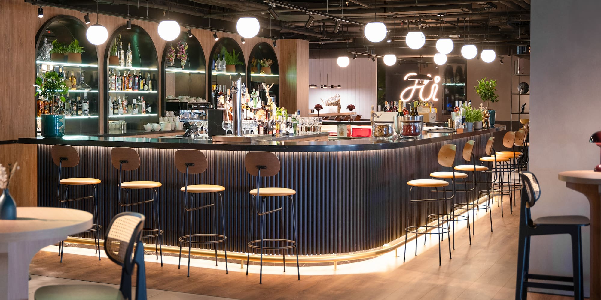 a bar with a row of stools and lights