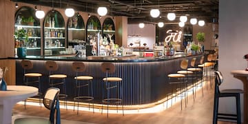 a bar with a row of stools and lights