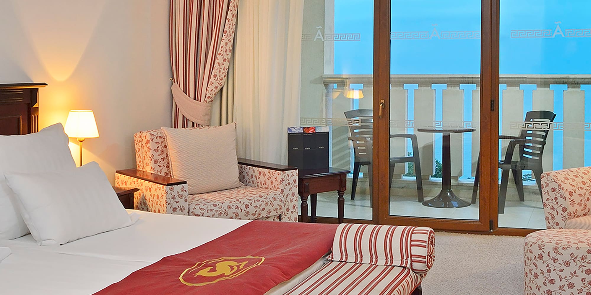 a room with a bed and chairs