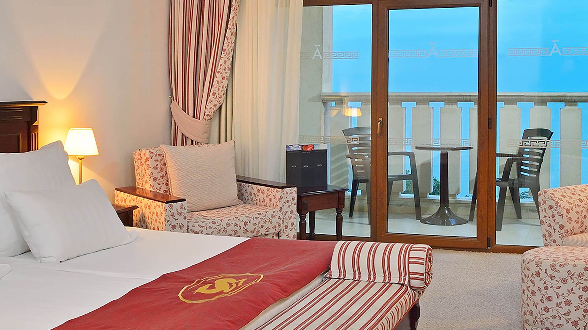 a room with a bed and chairs