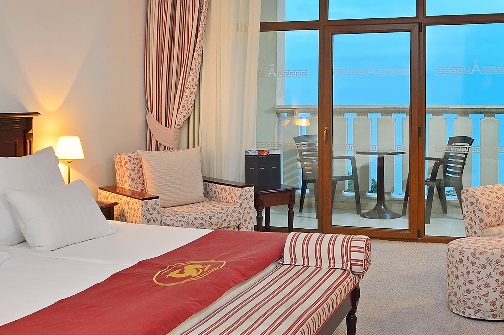 a room with a bed and chairs