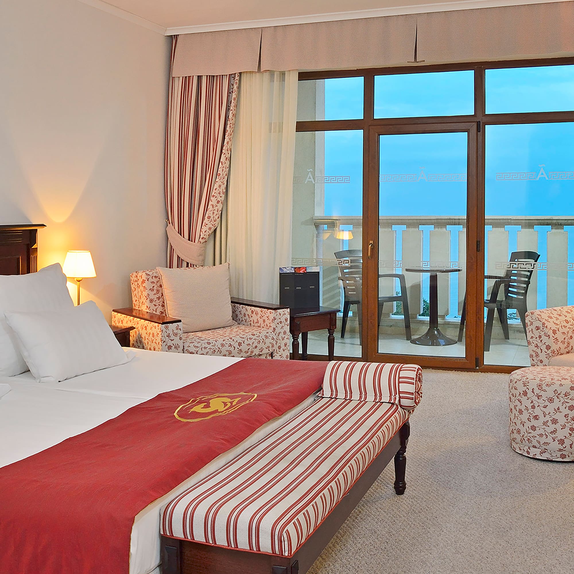 a room with a bed and chairs