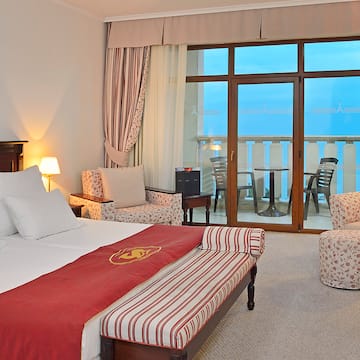 a room with a bed and chairs