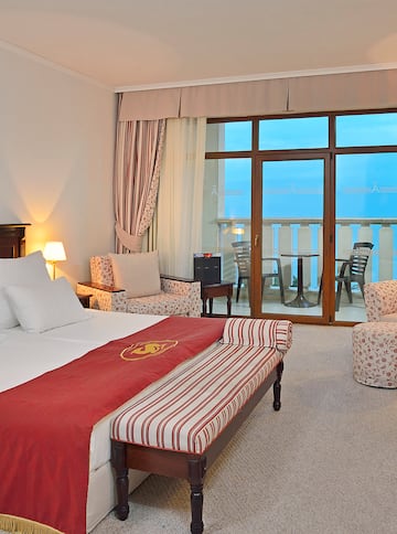 a room with a bed and chairs