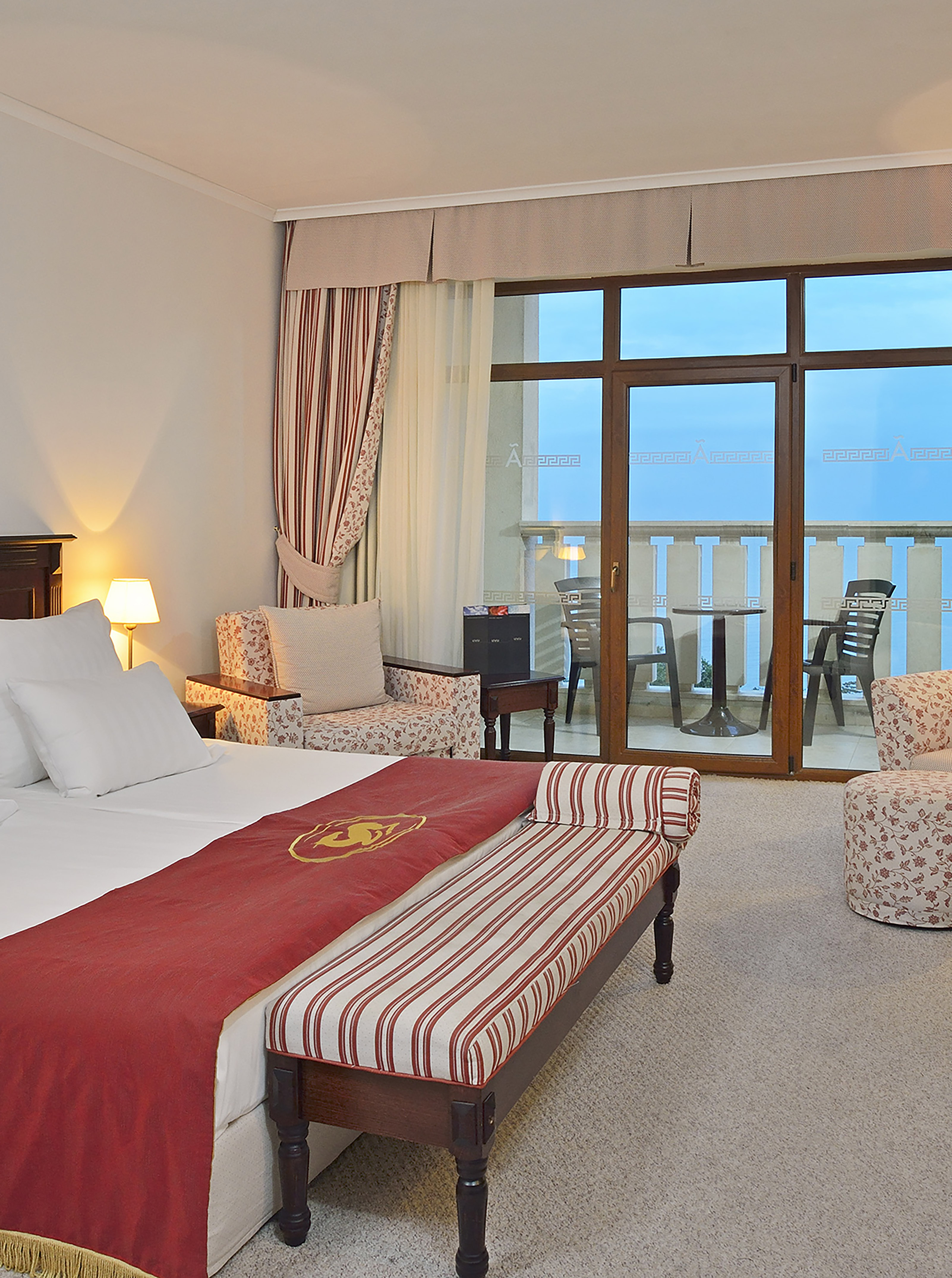 a room with a bed and chairs