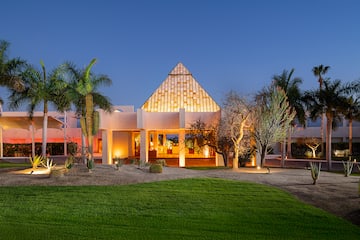 a house with a pyramid shaped roof and a lawn