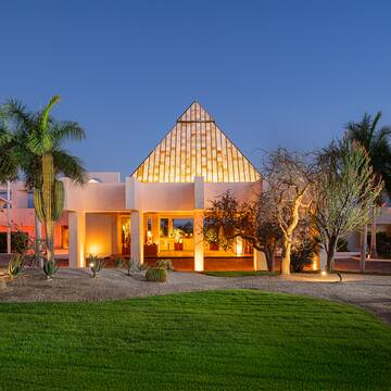 a house with a pyramid shaped roof and a lawn