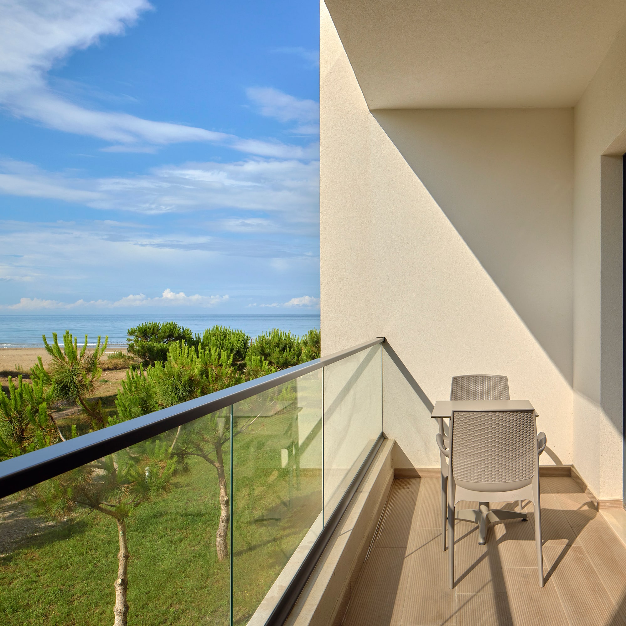 a balcony with a table and chairs overlooking a beach