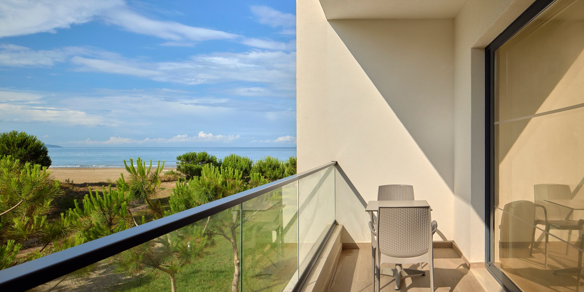 a balcony with a table and chairs overlooking a beach