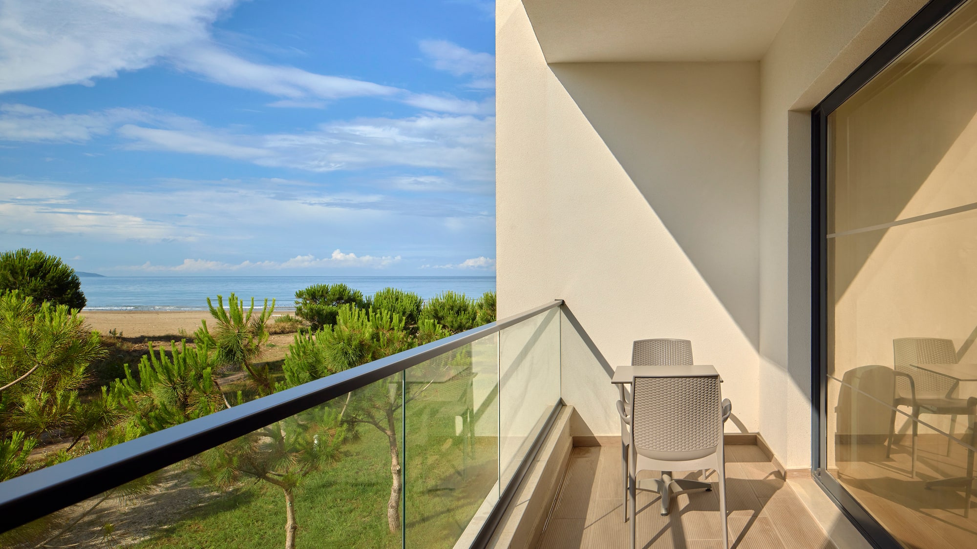 a balcony with a table and chairs overlooking a beach
