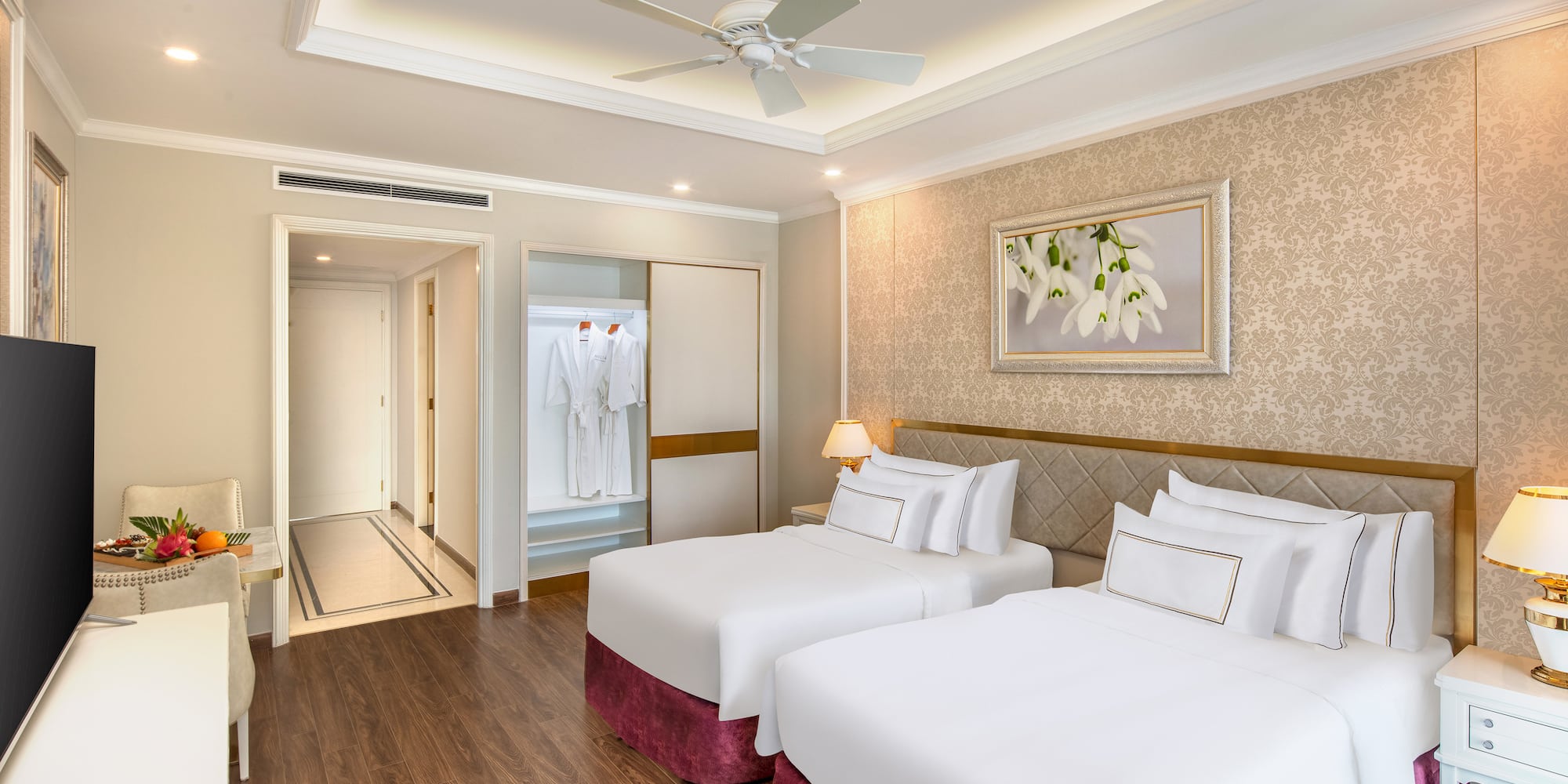 a room with two beds and a ceiling fan