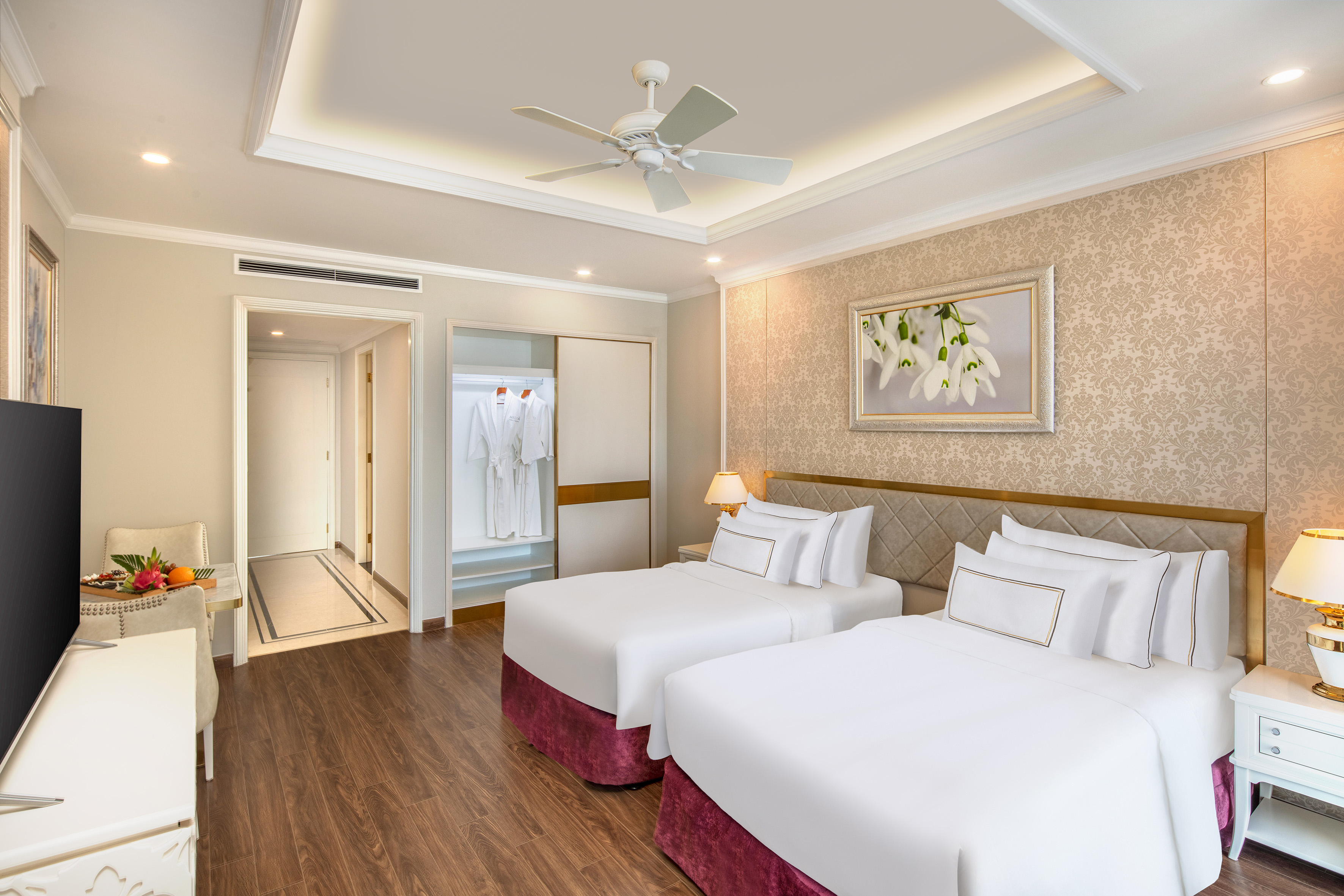 a room with two beds and a ceiling fan
