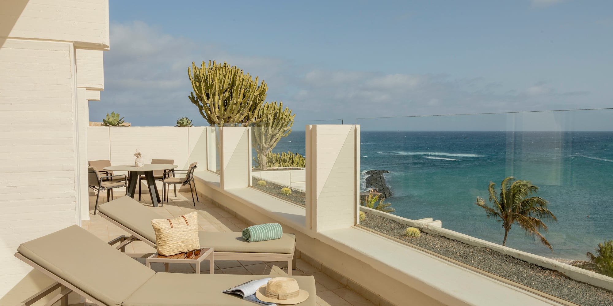 a deck with chairs and a view of the ocean