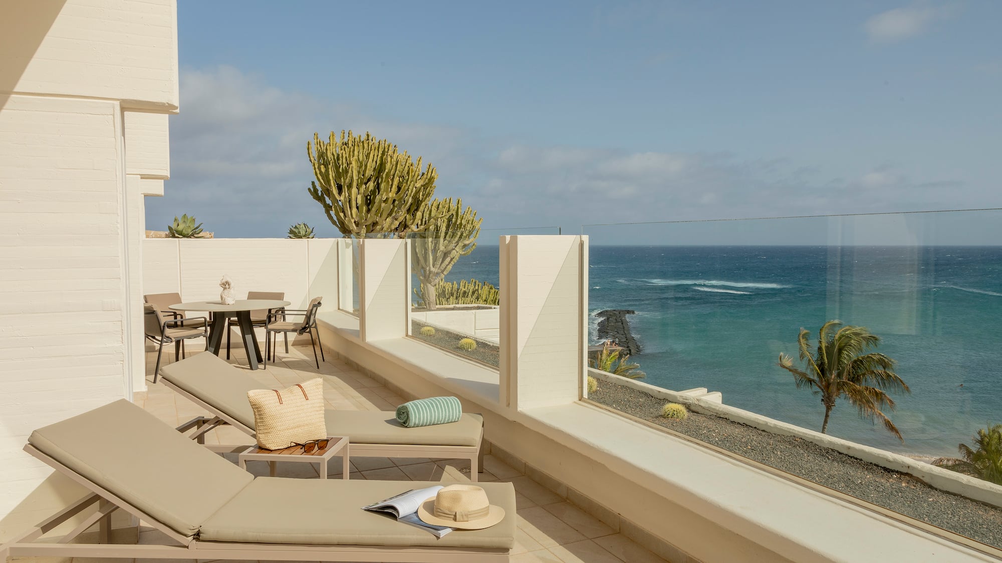 a deck with chairs and a view of the ocean