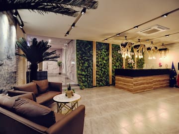 a lobby with a reception desk and plants