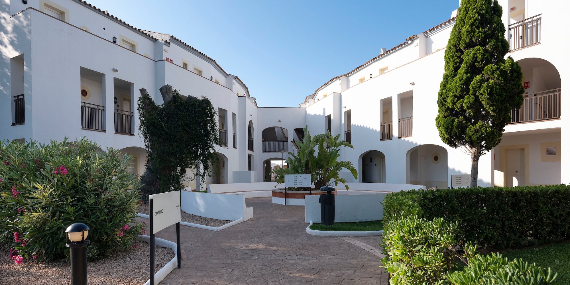 a white building with trees and bushes