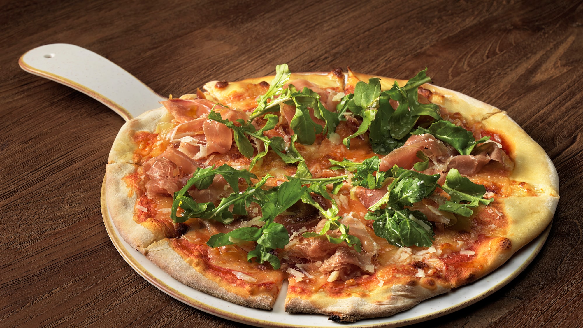 a pizza with greens on a white plate