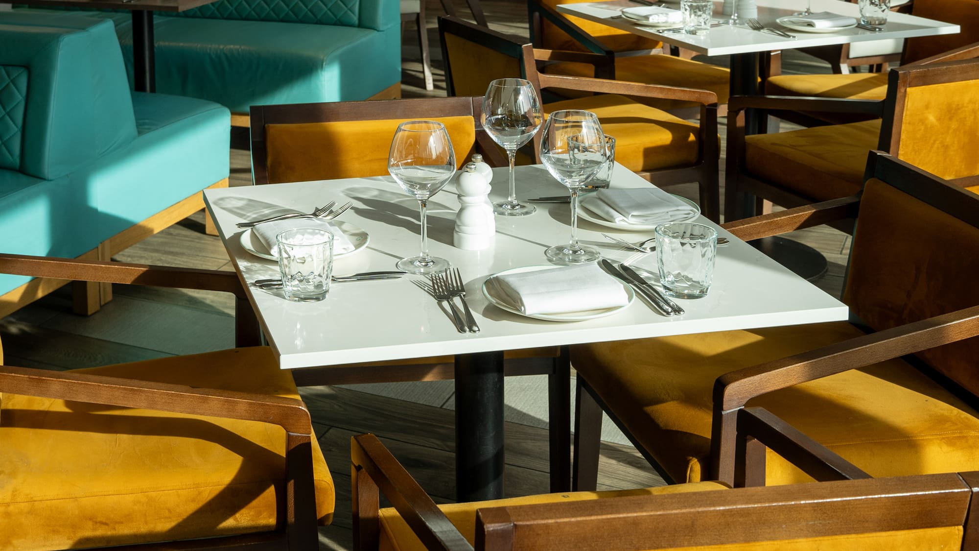 a table set up with empty glasses and plates