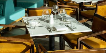 a table set up with empty glasses and plates